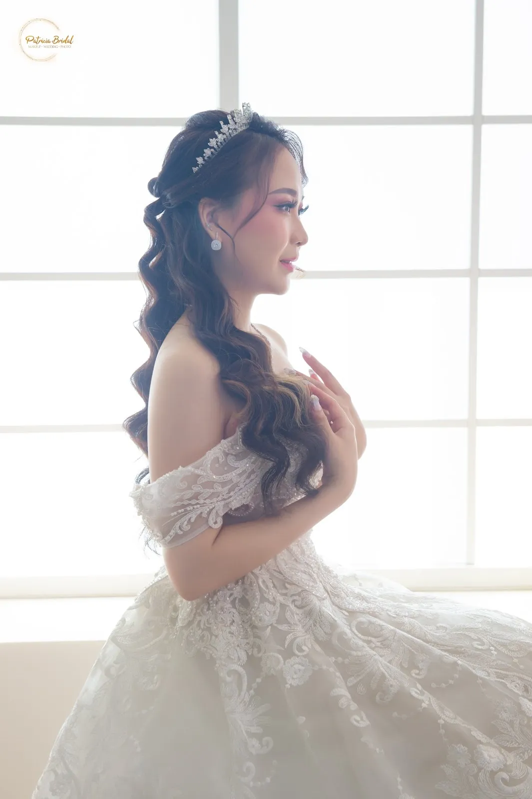 Pengantin dengan gaun renda off-shoulder dan rambut bergelombang panjang