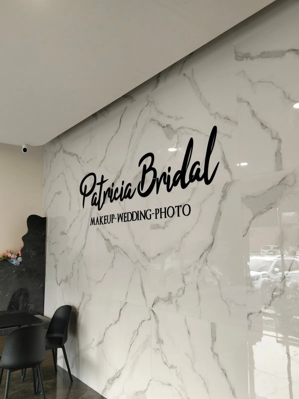 Dinding marmer berlogo Patricia Bridal di ruang depan butik